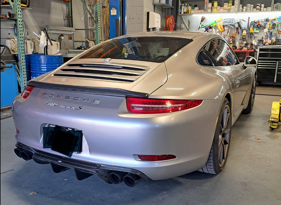 Porsche 911 Carrera S argentée arrière dans l'atelier Garage S.T.R.